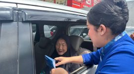 Petugas teller BRI kanca Cimanggis, Ainaya Lana Arista H melayani nasabah pensiunan dengan memberikan pendampingan administrasi di dalam kendaraan (Foto Istimewa) 